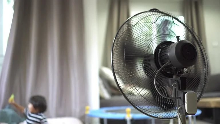 Close-up of a modern, sleek desk fan providing a cool breeze